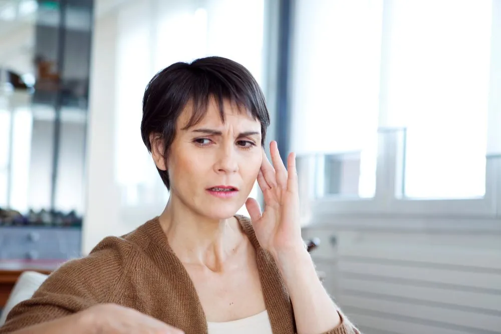 A woman holding her ear in pain