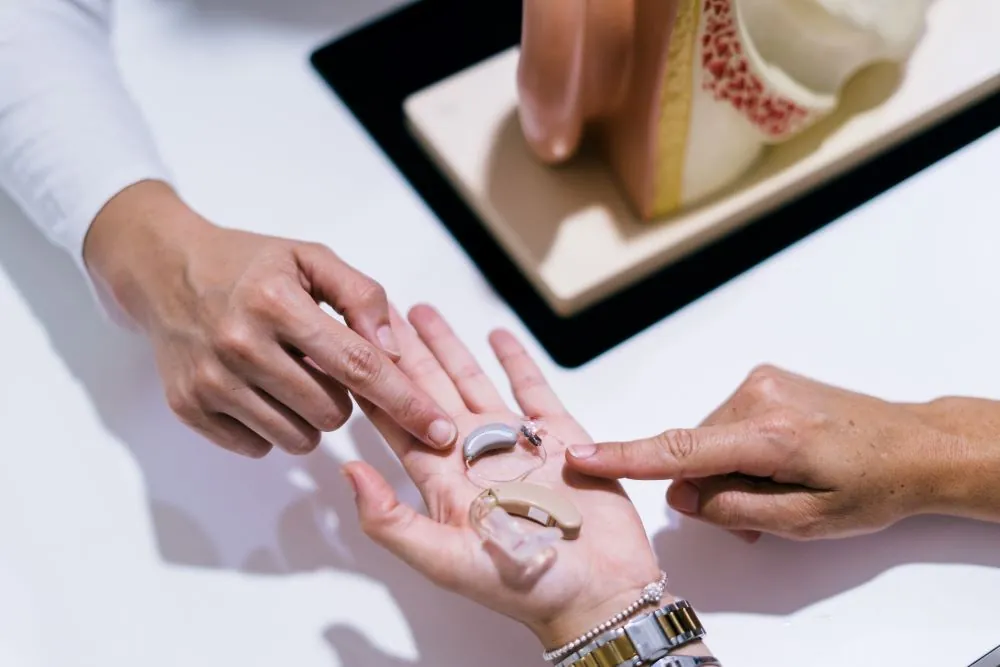 Close up open hand holding hearing aids