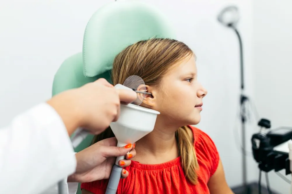 Young girl getting ear wax removed