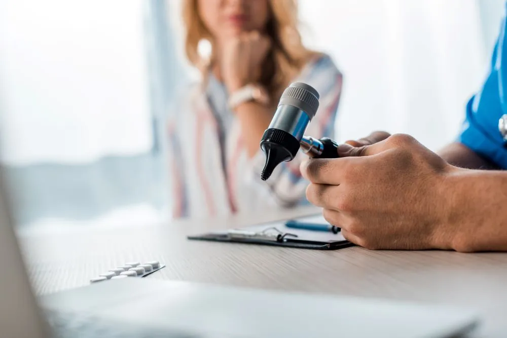 Focused view of audiologist holding otoscope