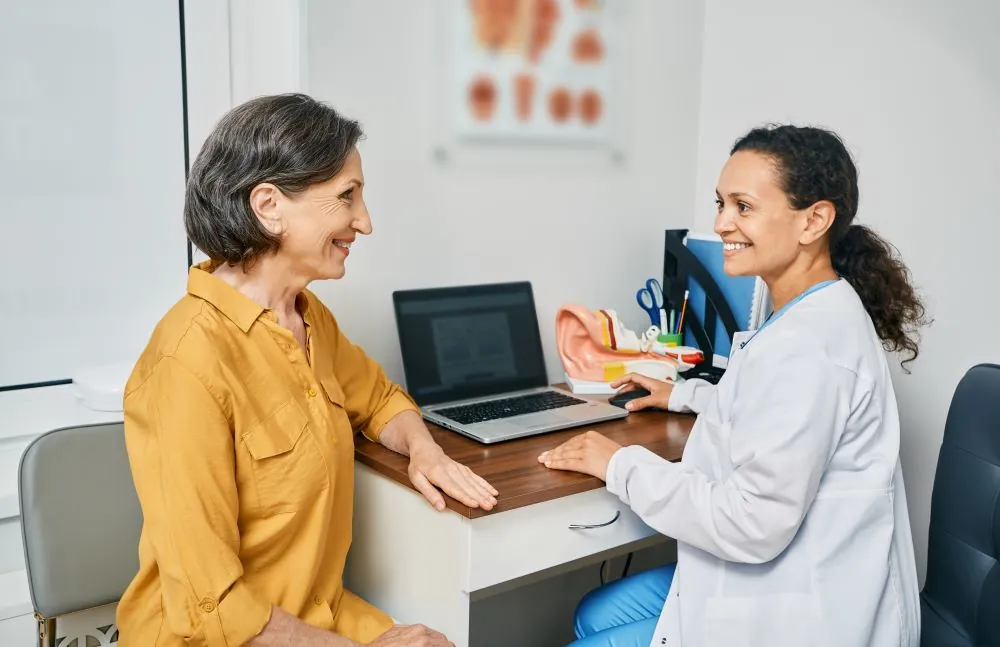 Woman sat with their audiologist