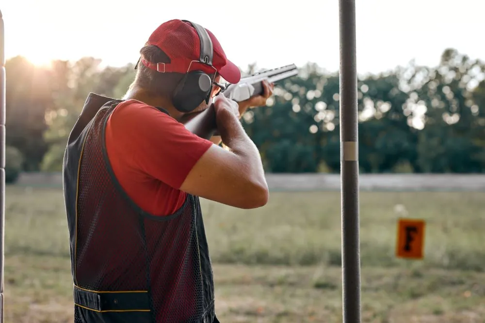 Man wearing ear plugs whilst at a shooting range