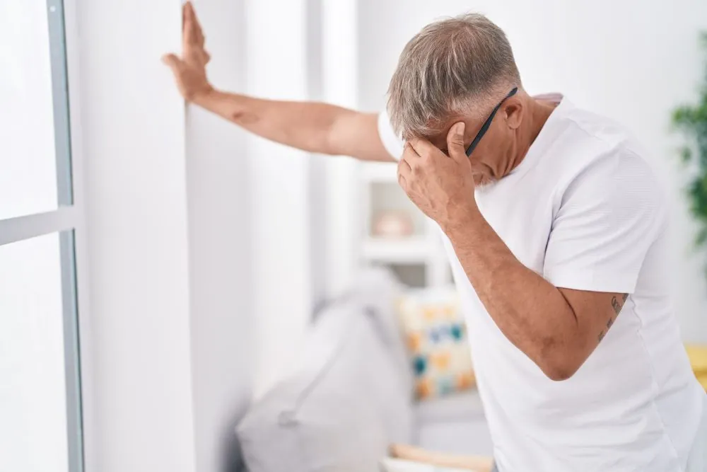 Middle aged man suffering from dizziness whilst standing up