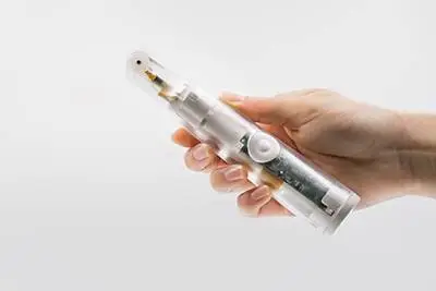 A hand holding a NuLids device